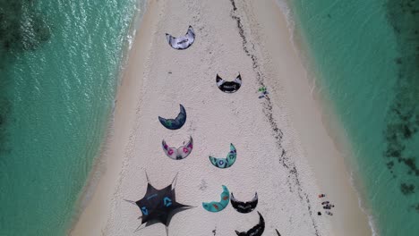 aerial reveal of people swimming, their kite surf kit on isthmus and island of cayo de agua