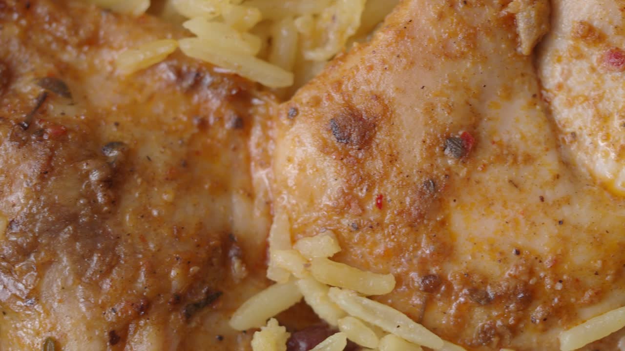 Primo piano di pollo speziato e riso giallo