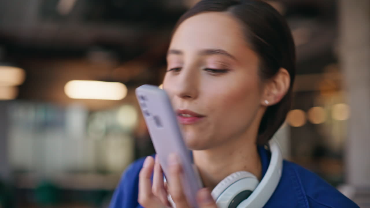Happy hipster calling cellphone sitting urban cafe with headset on neck closeup