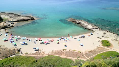 Playa-De-Arena-Blanca-Y-Agua-Azul-Turquesa-Entre-La-Cala-De-Rocas-En-La-Isla-De-Cerdeña,-Italia