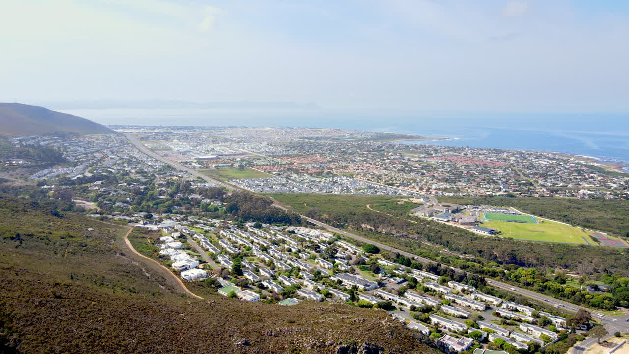 High angle wide aerial view over suburbs of Hermanus toward Atlantic coastline