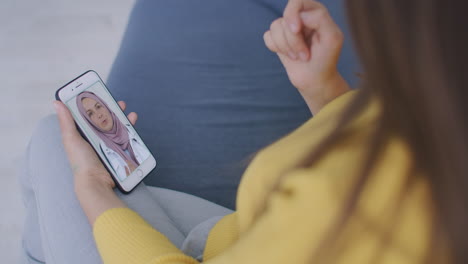 una chica habla con un médico en un hijab usando un enlace de video. trabajo remoto de una mujer musulmana médico