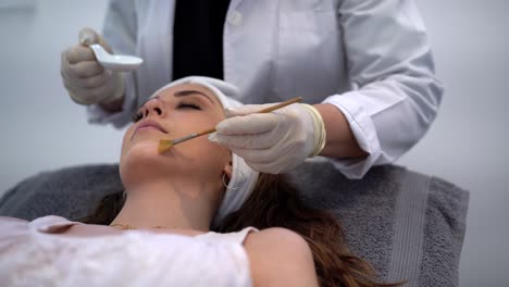 esteticista de cultivos aplicando exfoliación de ácido en la cara de la mujer