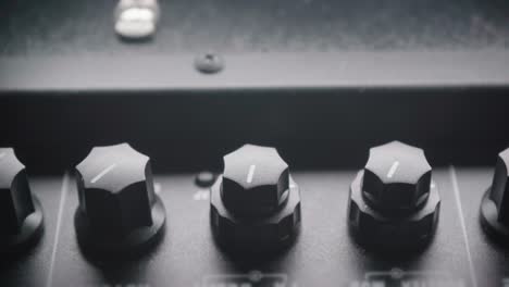 adjusting tone knobs on a guitar amplifier