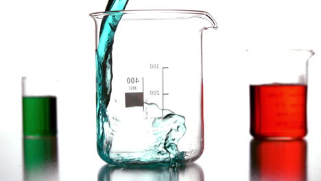 blue liquid pouring into beaker