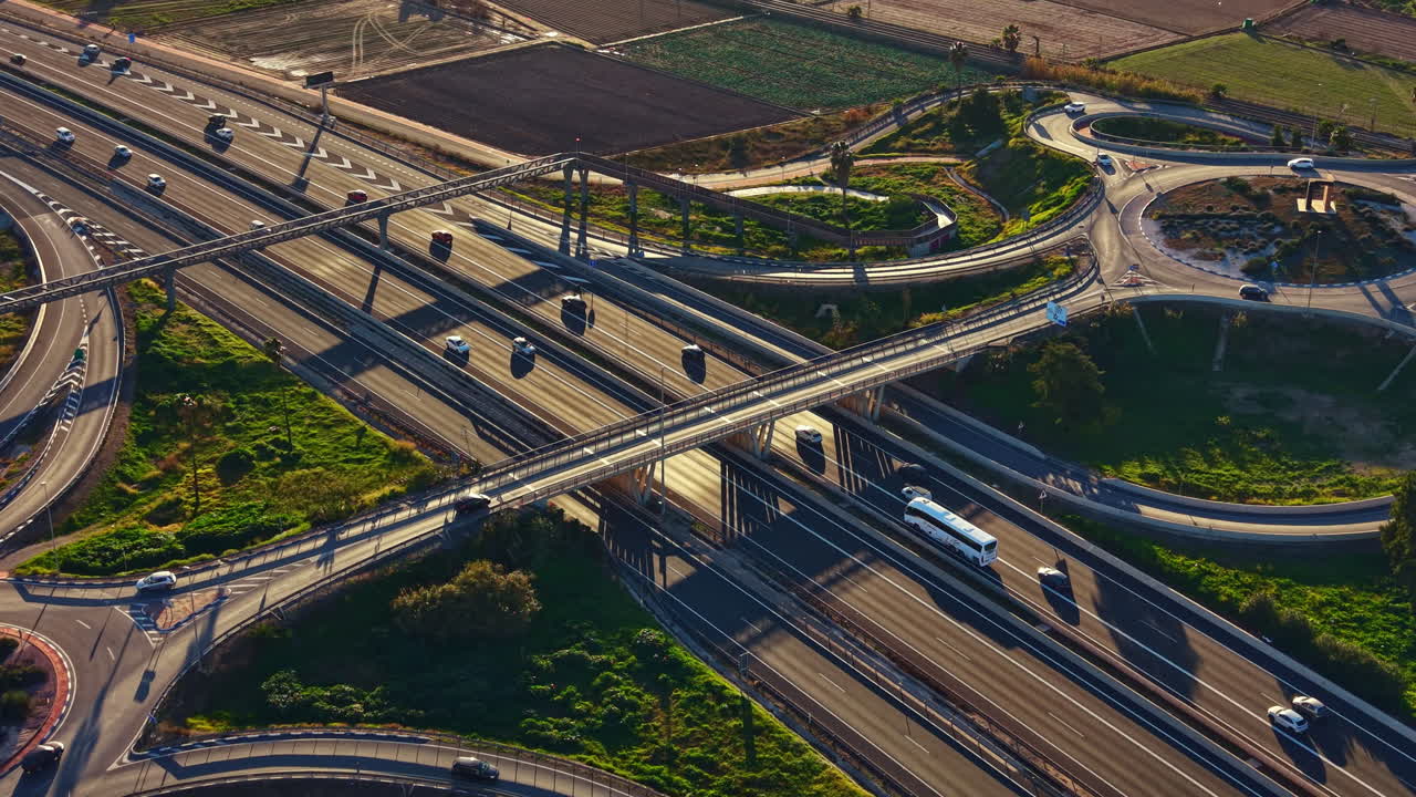 Highway interchange with traffic and green spaces in the background during the late afternoon in a suburban area