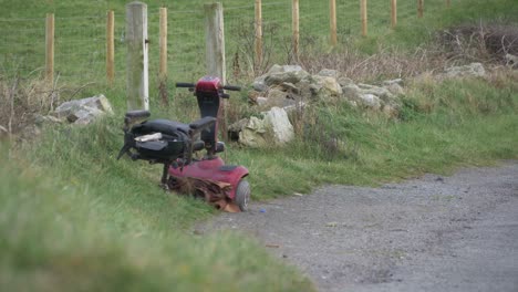viejo scooter de movilidad eléctrica desgastado dejado en la carretera