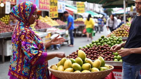 fruit vendor and customer in a street market