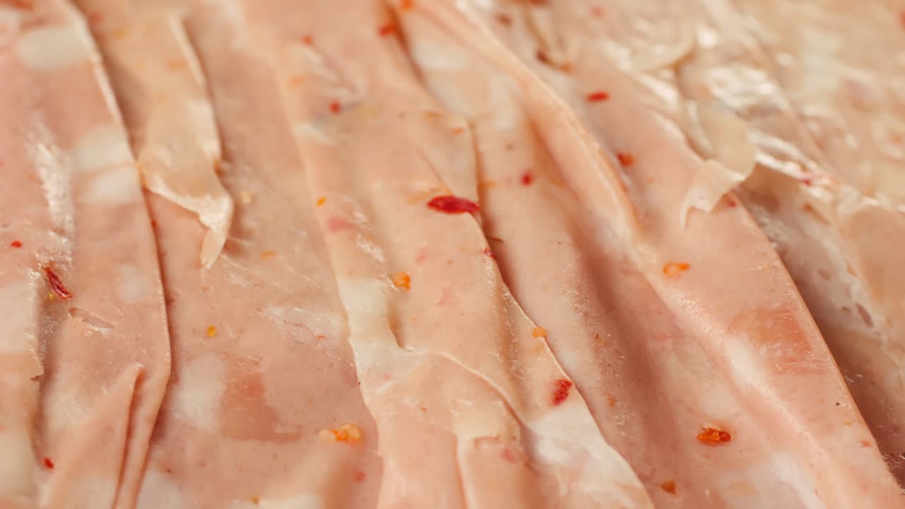 Ham italian mordatella, man Slices Of Traditional Italian antipasti mortadella sausage on a wooden cutting board, close up macro of chicken or turkey jamon, fat breakfast dish.