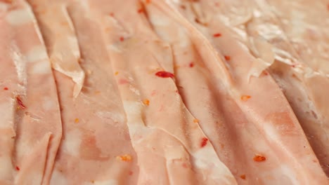 ham italian mordatella, man slices of traditional italian antipasti mortadella sausage on a wooden cutting board, close up macro of chicken or turkey jamon, fat breakfast dish.