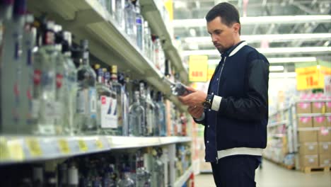 hombre eligiendo vodka en una tienda de licor