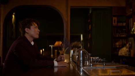 lonely asian man sitting at a bar, drinking and reflecting in solitude at night