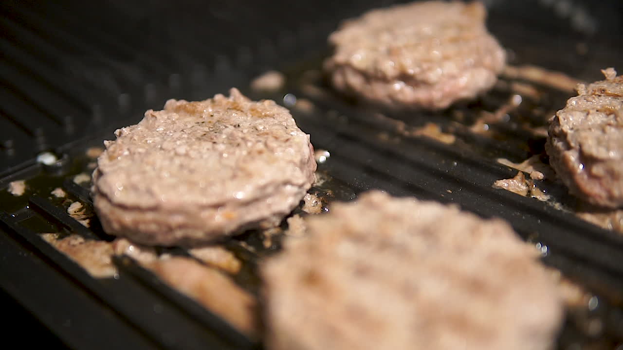 Juicy Burger Patties Cooking In A Grill Pan At Home