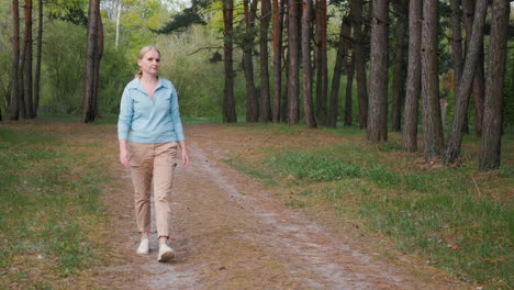 mujer caminando por un bosque de pinos