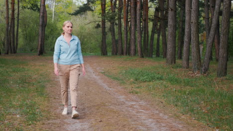 woman walking through a pine forest