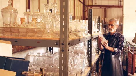 glassblower arranging a glass vase on the shelf