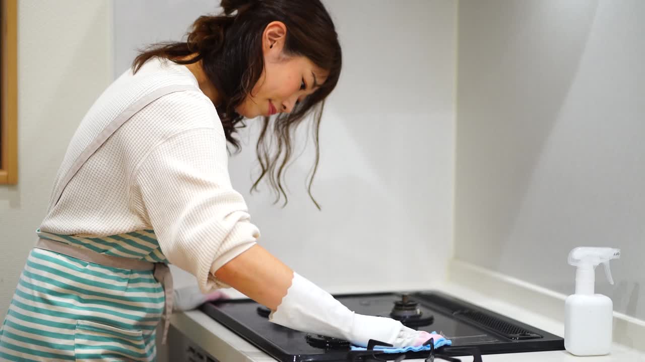 una mujer limpiando una estufa de gas