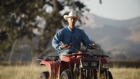 Cowboy-Reitet-Während-Der-Goldenen-Stunde-Mit-Seinem-Quad-Durch-Bewässerte-Weiden