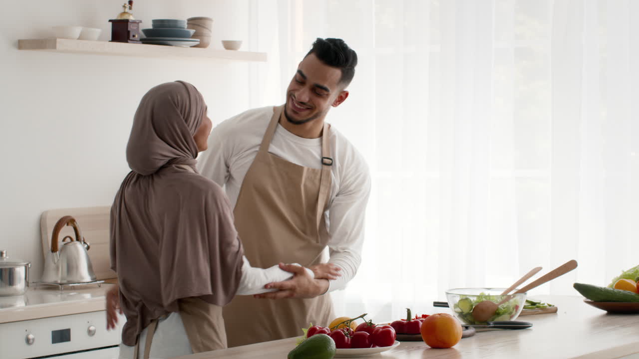 una pareja feliz abrazándose en la cocina.