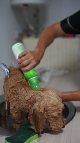 perro siendo bañado en un fregadero de la cocina