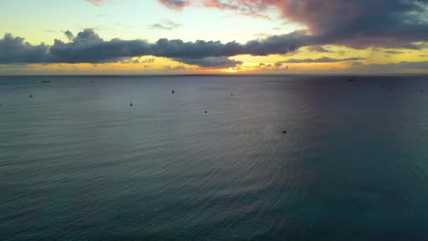 A-Fleet-of-Sailboats-in-a-Hawaiian-Sunset-Traveling-Across-The-Ocean-Waves-and-Wind-Off-the-Coast-of-Waikiki-Beach-In-Honolulu---Aerial-Drone-View