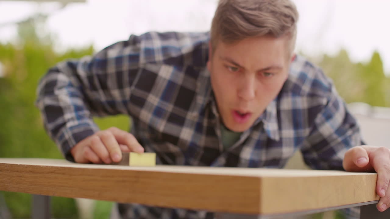 Man Sanding a Wooden Table