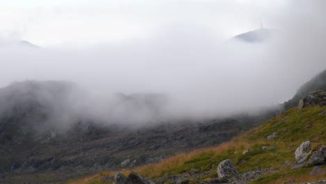densa niebla que cubre la cima de la montaña y cubre lentamente la ladera de la montaña