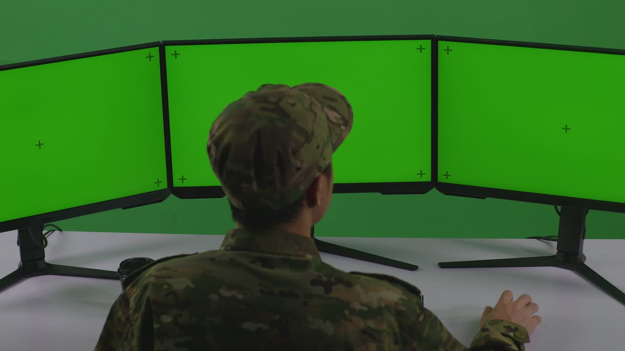 personal militar trabajando en computadoras con monitores de pantalla verde