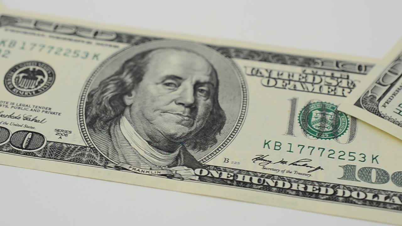 Dollari su sfondo bianco. Riprese in movimento.