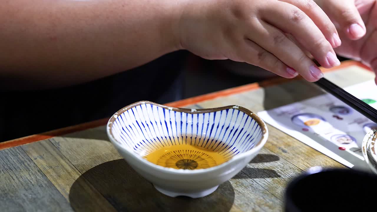 persona vierte la salsa en un cuenco pequeño