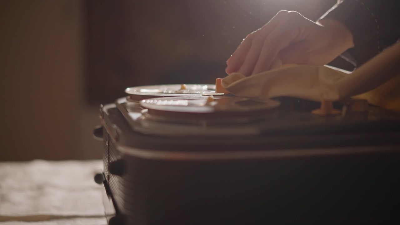 Careful cleaning of vintage recorder. Meticulous handling restores old magnetic tape equipment perfectly. Skilled technicians gently clean and repair vintage tape recorders with precision and care