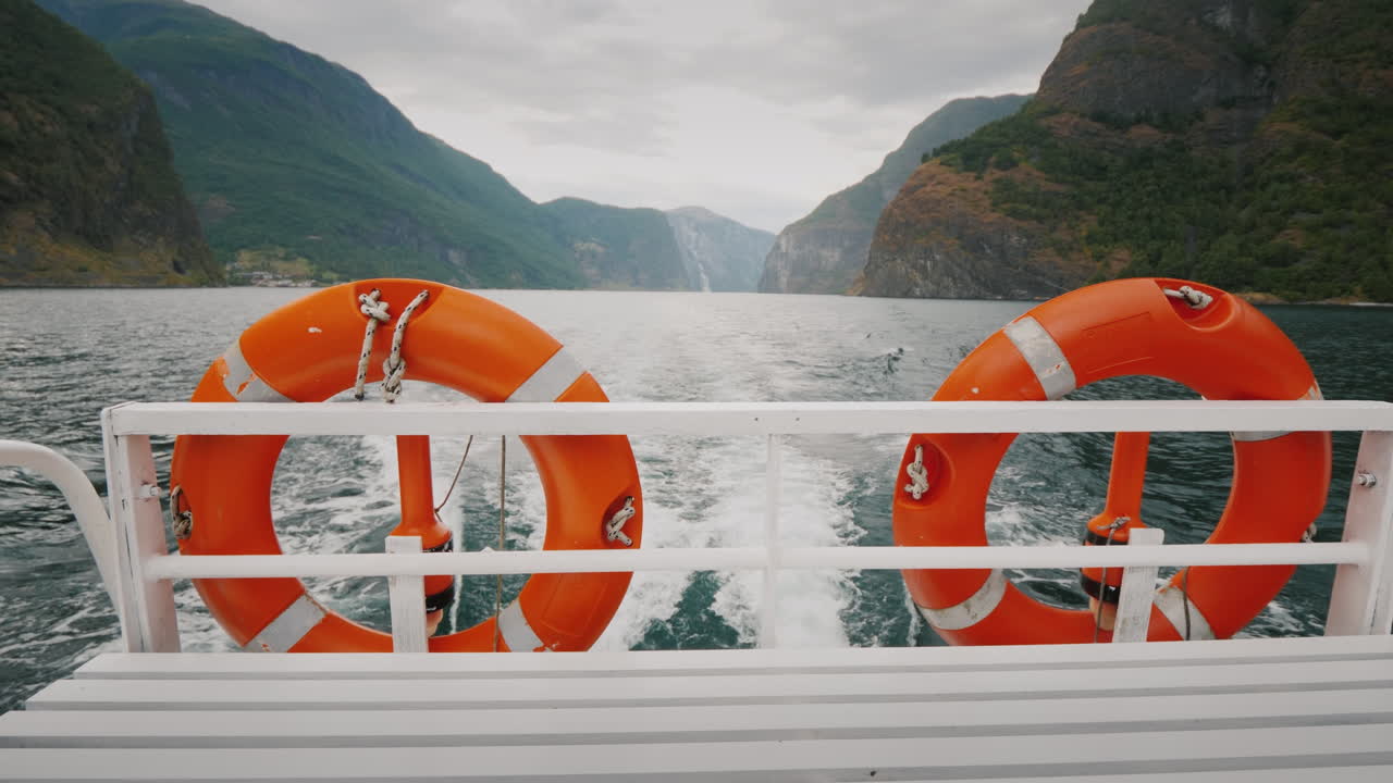 그림 같은 노르웨이 피요르드 4k 비디오를 배경으로 두 개의 구명부표가 있는 유람선 크루즈
