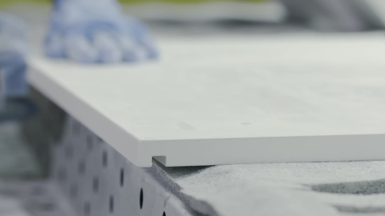 trabajador que lijaba una superficie blanca en un entorno de fabricación