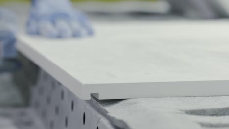 worker sanding a white surface in a manufacturing setting