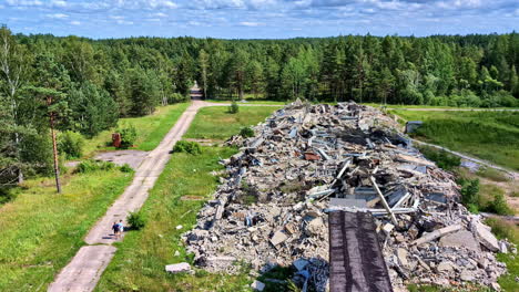 large pile of demolition rubble and construction waste next to a forest road