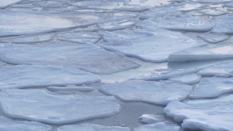 arctic-northern-norway-winter-,-large-pieces-of-melting-ice-floating-on-a-sea-surface,-long-duration-beautiful-nature-footage