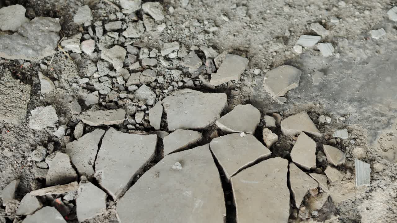 Fractured concrete slabs reveal damage, wear on exposed floor at renovation site