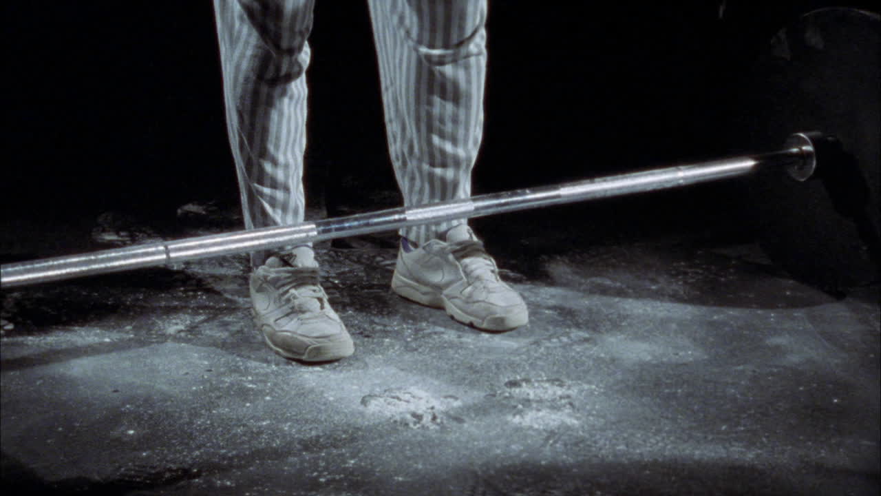 한 남자가 매우 무거운 바벨을 들어 올립니다