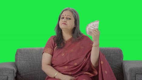 Confident-Indian-old-woman-using-money-as-fan-Green-screen