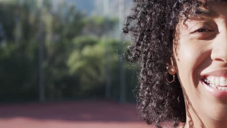 Half-portrait-of-female-african-american-basketball-player-on-sunny-court,-copy-space,-slow-motion