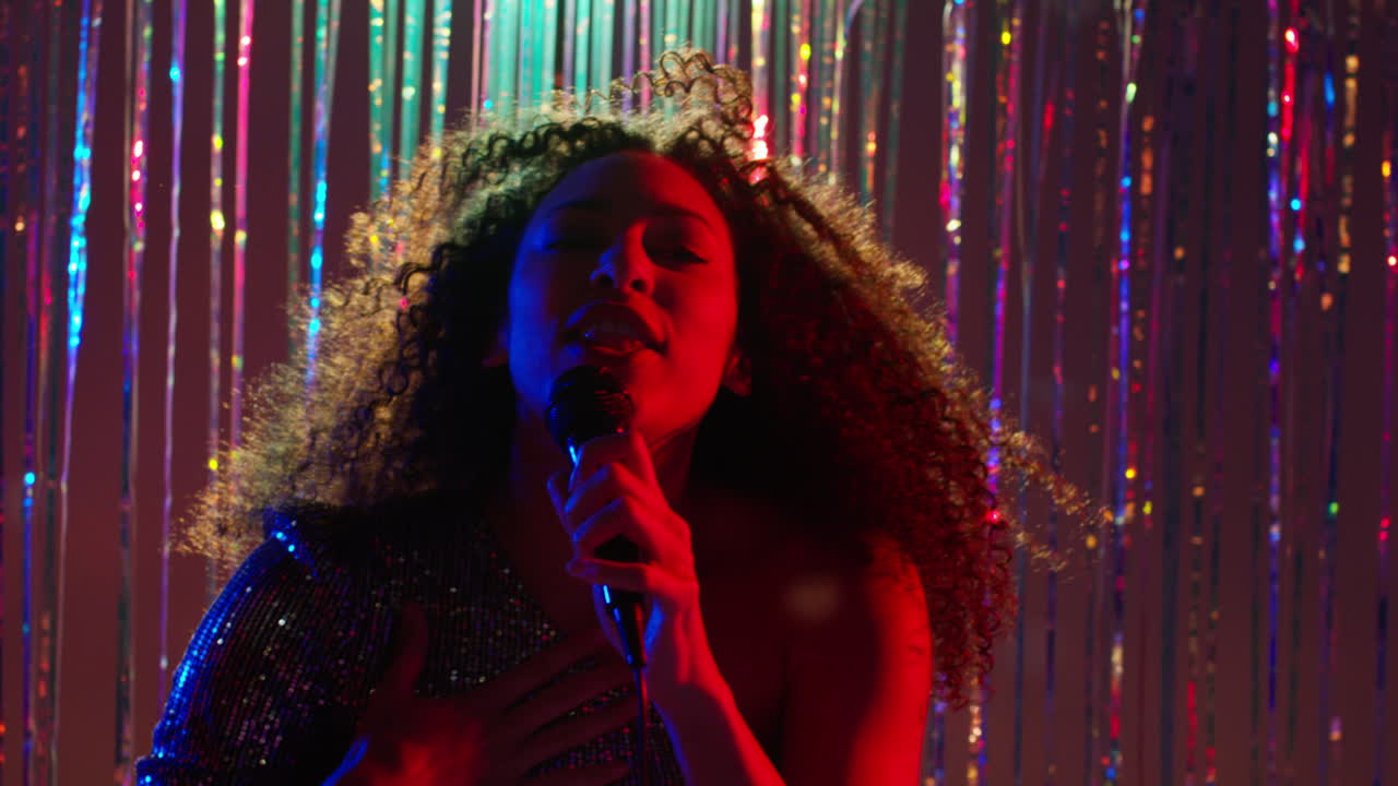 Young Woman With Microphone Singing At Karaoke Nightclub Bar Or Disco With Sparkling Lights In Background 3