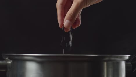 añadiendo sal a una olla