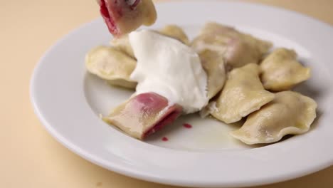 pierogi with sour cream and red filling