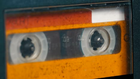 the vintage yellow audio cassette in the tape recorder rotates