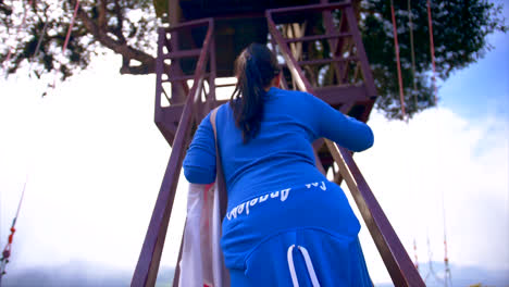 woman in blue climbing the stairs