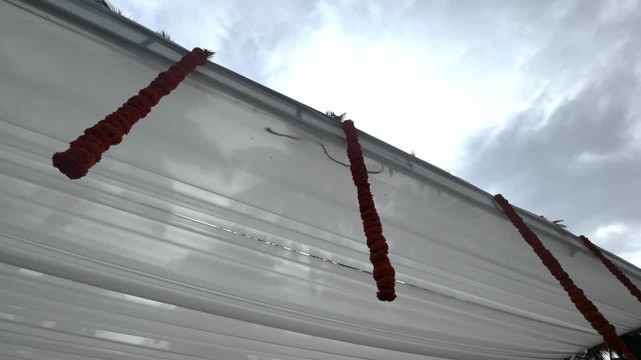 Indian Wedding Decor With Artificial Flower Garlands During A Cloudy Day. Low Angle Shot