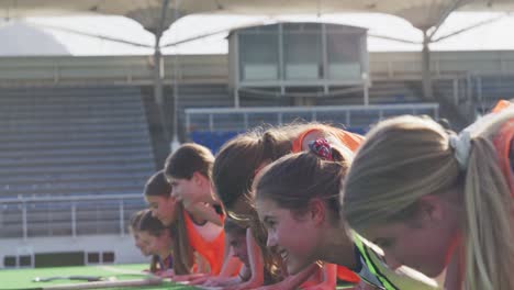 female hockey players doing push-ups on the field