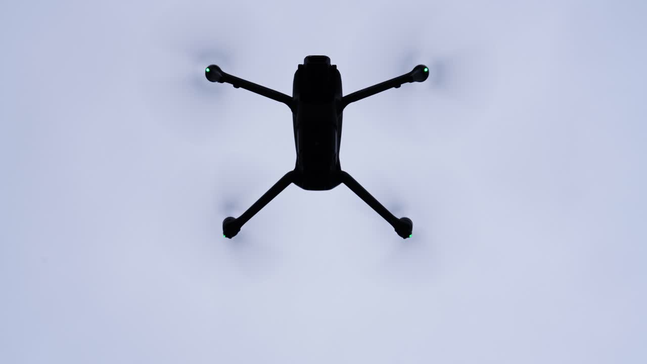 Dark drone silhouette hover in air and increase altitude, Czech Republic