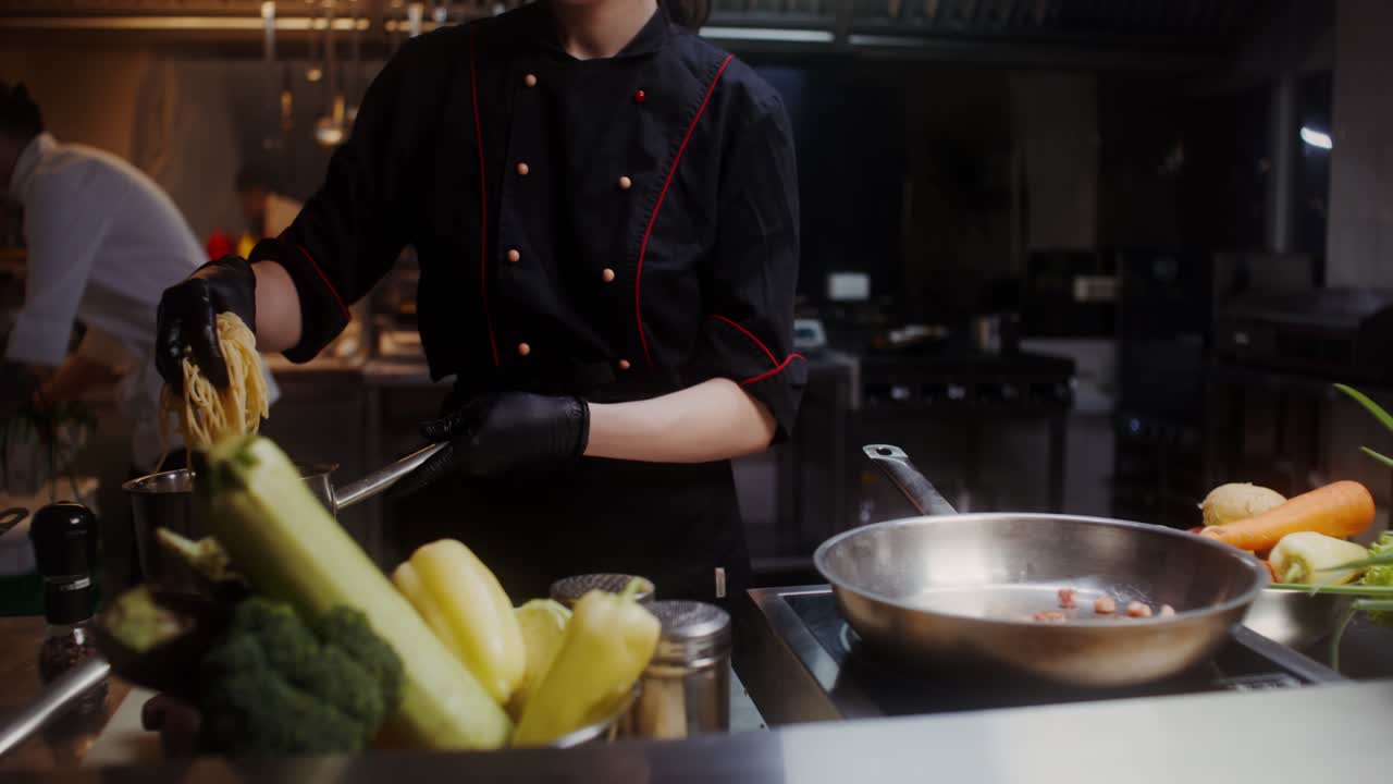 Chef che prepara gli spaghetti in una cucina di un ristorante