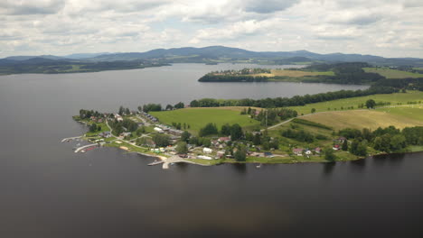 Village-on-shore-of-Lipno-water-reservoir-peninsula-below-cloudy-sky